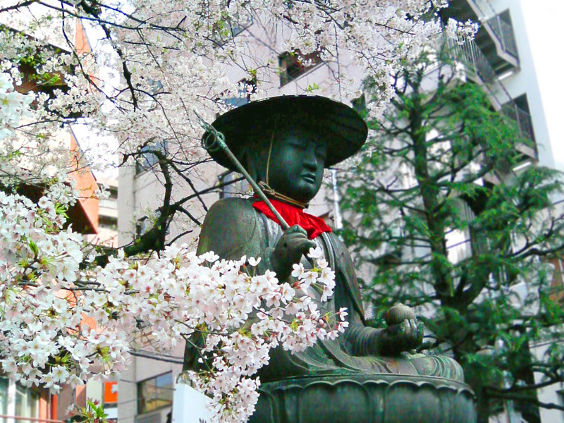 A large bronze statue of Kasa-Jizō, Jizō bodhisattva (Jizō-bosatsu ) with a conical hat, at the entrance of Taisō-ji temple.