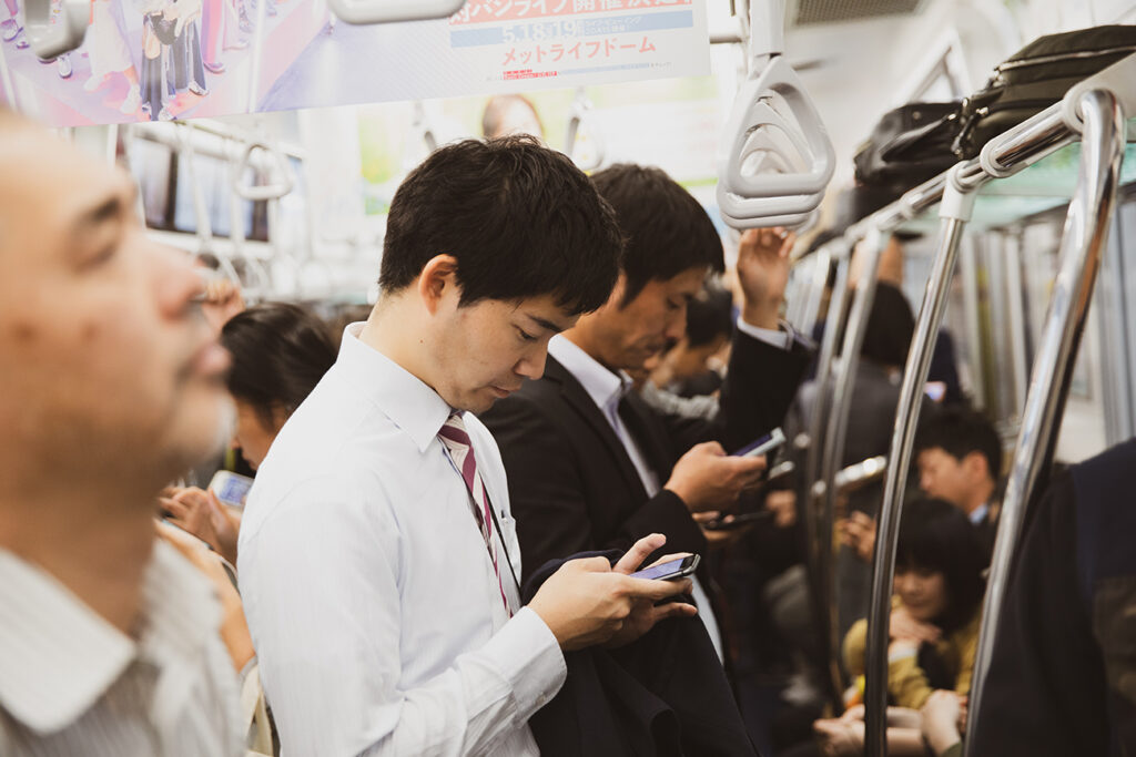 TOKYO- MAY 10, 2019 : Passenger using smartphone in Tokyo jr train line.East Japan Railway Company is a major passenger railway company in Japan and one of the seven Japan Railways Group companies.